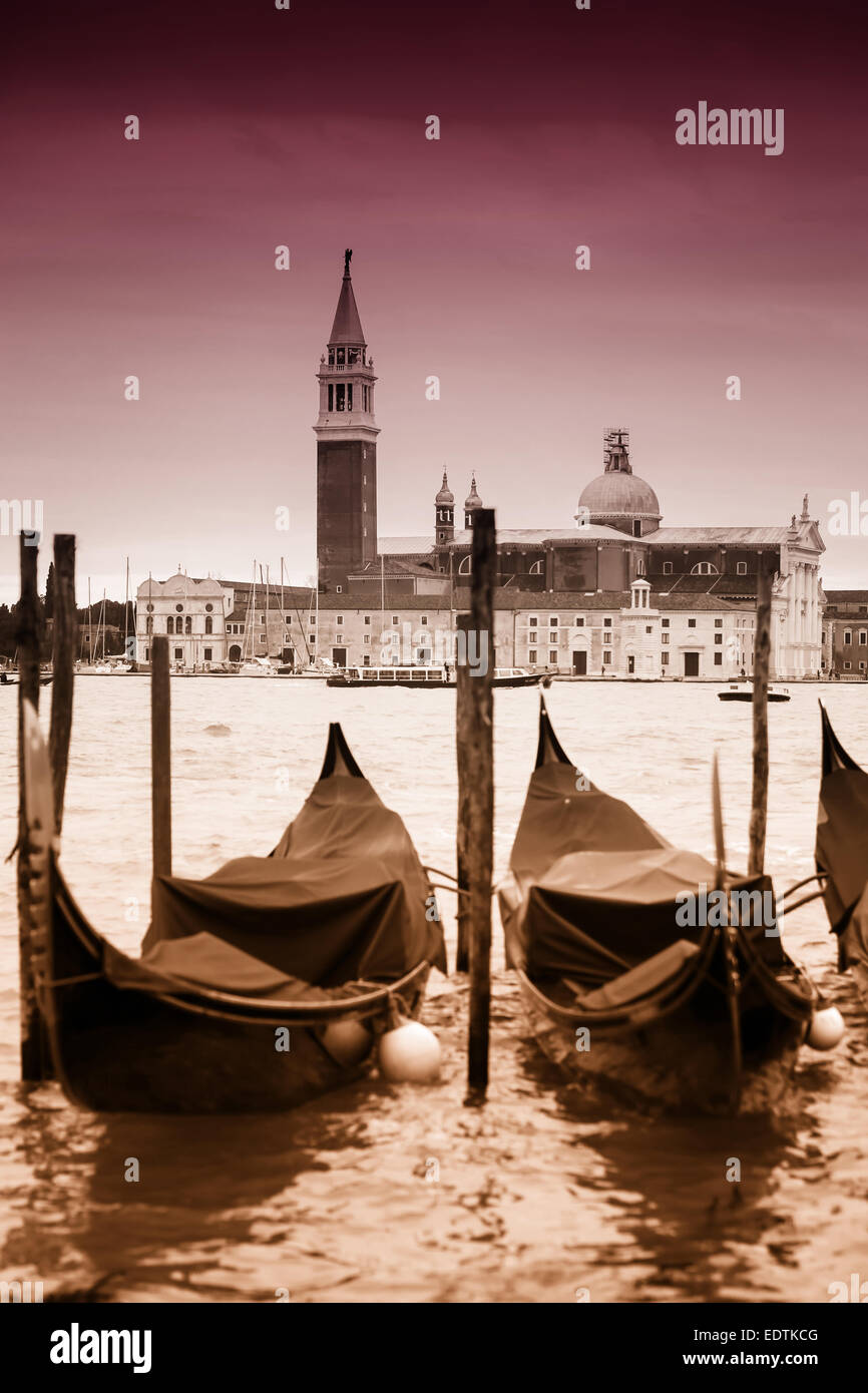 Una veduta della chiesa di San Giorgio Maggiore sull'isola di San Giorgio Maggiore con gondole parcheggiata nell'acqua di Venezia. Foto Stock