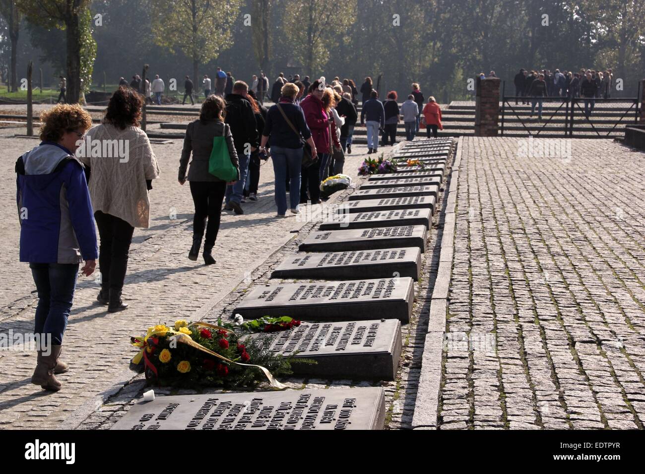 I visitatori a piedi passato il memoriale di commemorazione delle vittime del fascismo, che è stato inaugurato nel 1967, nel campo di concentramento di Auschwitz in Oświęcim, Polonia, 5 ottobre 2014. Una stima di un milione e mezzo di persone sono state assassinate ad Auschwitz. Il camp è stata liberata dalle truppe sovietiche il 27 gennaio 1945 ed è stato trasformato in un memoriale e museo nel 1947. Il camp è stato dal 2007 un nella lista UNESCO patrimonio dell'umanità, ufficiale chiamato come 'Auschwitz-Birkenau - Tedesco nazionale socialista di concentrazione e di sterminio camp'. Foto: Frank Schumann/dpa - nessun filo SERVICE - Foto Stock