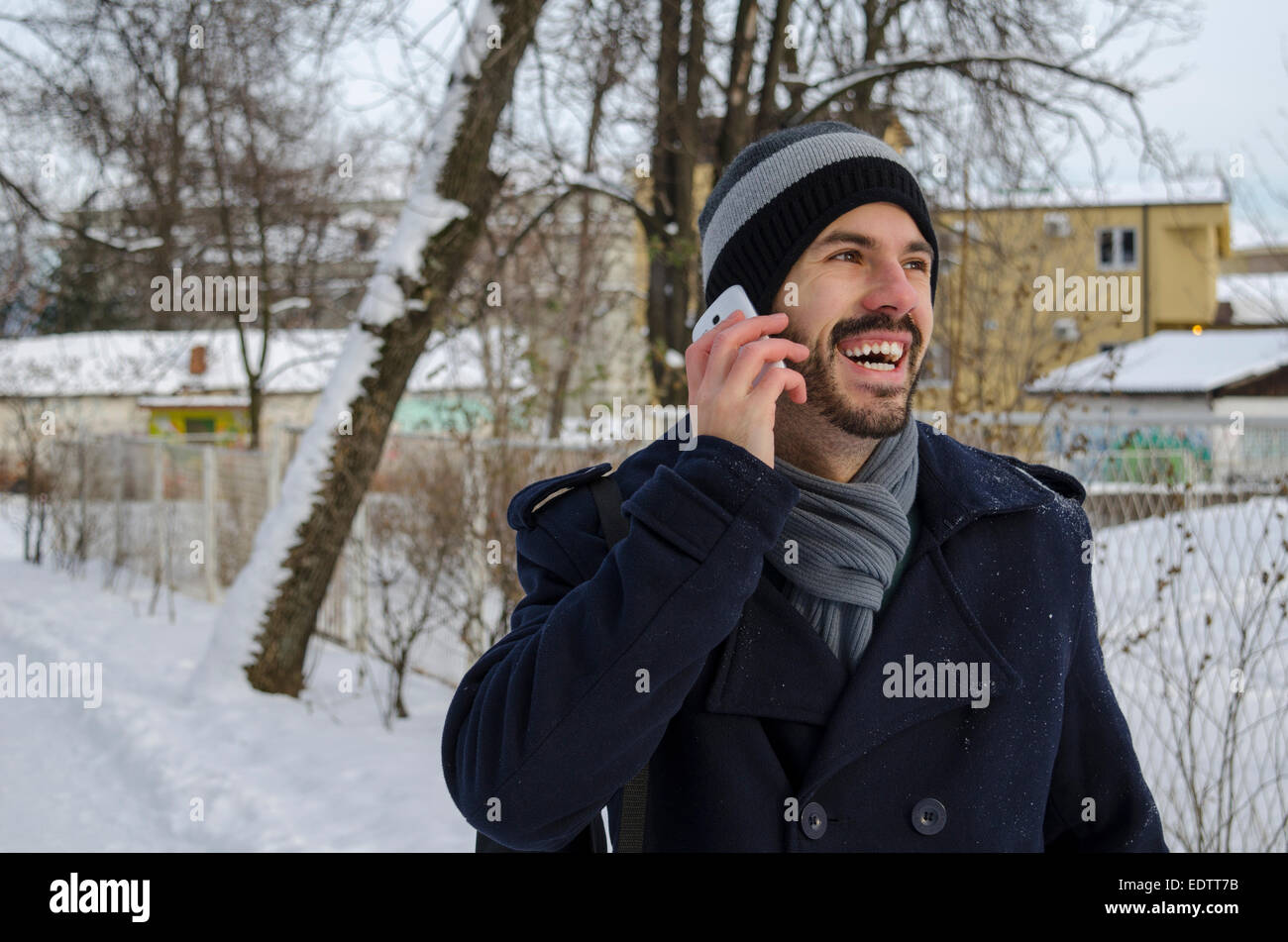 Uomo Barbuto a parlare su un telefono cellulare in inverno Foto Stock