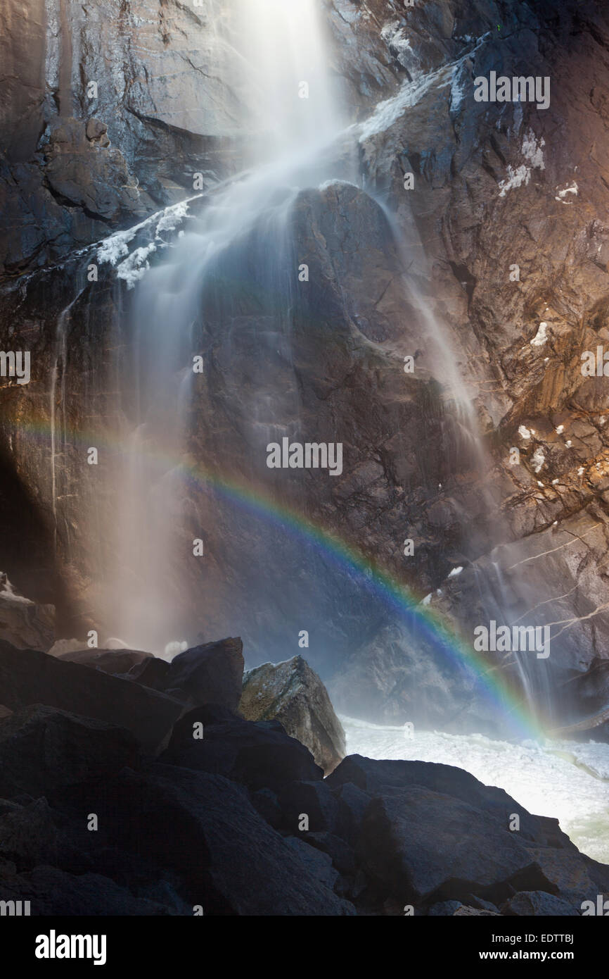Acqua, arcobaleno e ghiaccio in corrispondenza della base inferiore di Yosemite Falls nel Parco Nazionale di Yosemite Foto Stock