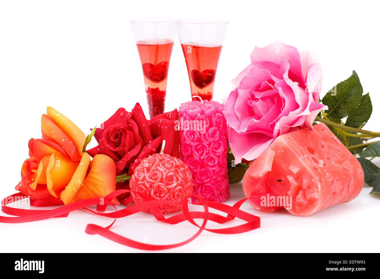 Due bicchieri, candele e rose isolati su sfondo bianco. Foto Stock