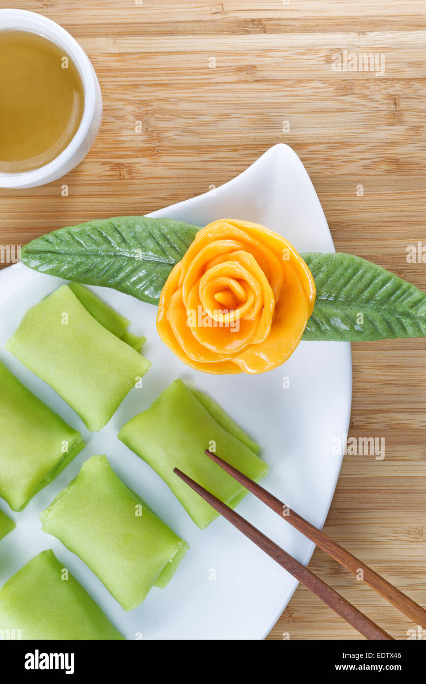 Close up top visualizza l'immagine verticale di Durian cinese dessert di frutta torte di riso, giallo Decorazione rose e il tè verde Foto Stock
