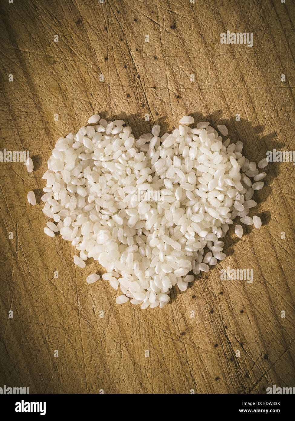 Cuore di riso su sfondo di legno in un overhead shot Foto Stock