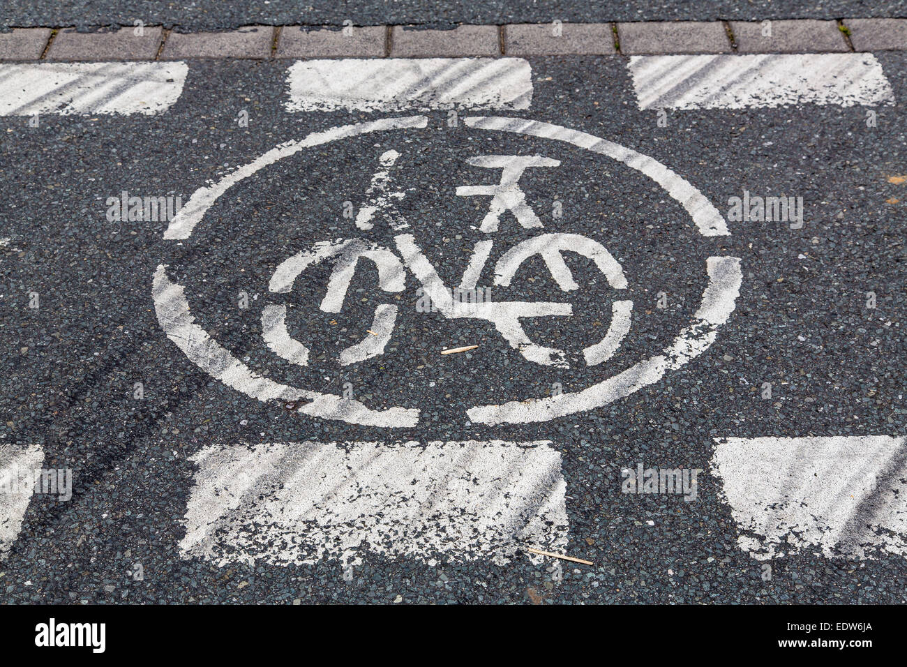 I cartelli stradali per il percorso in bicicletta, dipinta sul marciapiede, usurato Foto Stock
