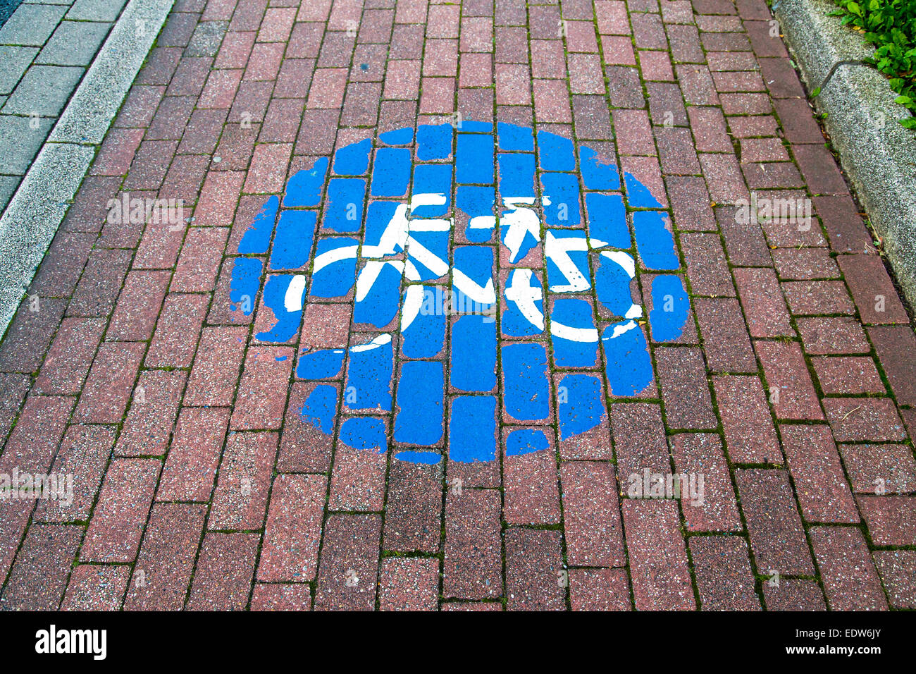 I cartelli stradali per il percorso in bicicletta, dipinta sul marciapiede, usurato Foto Stock