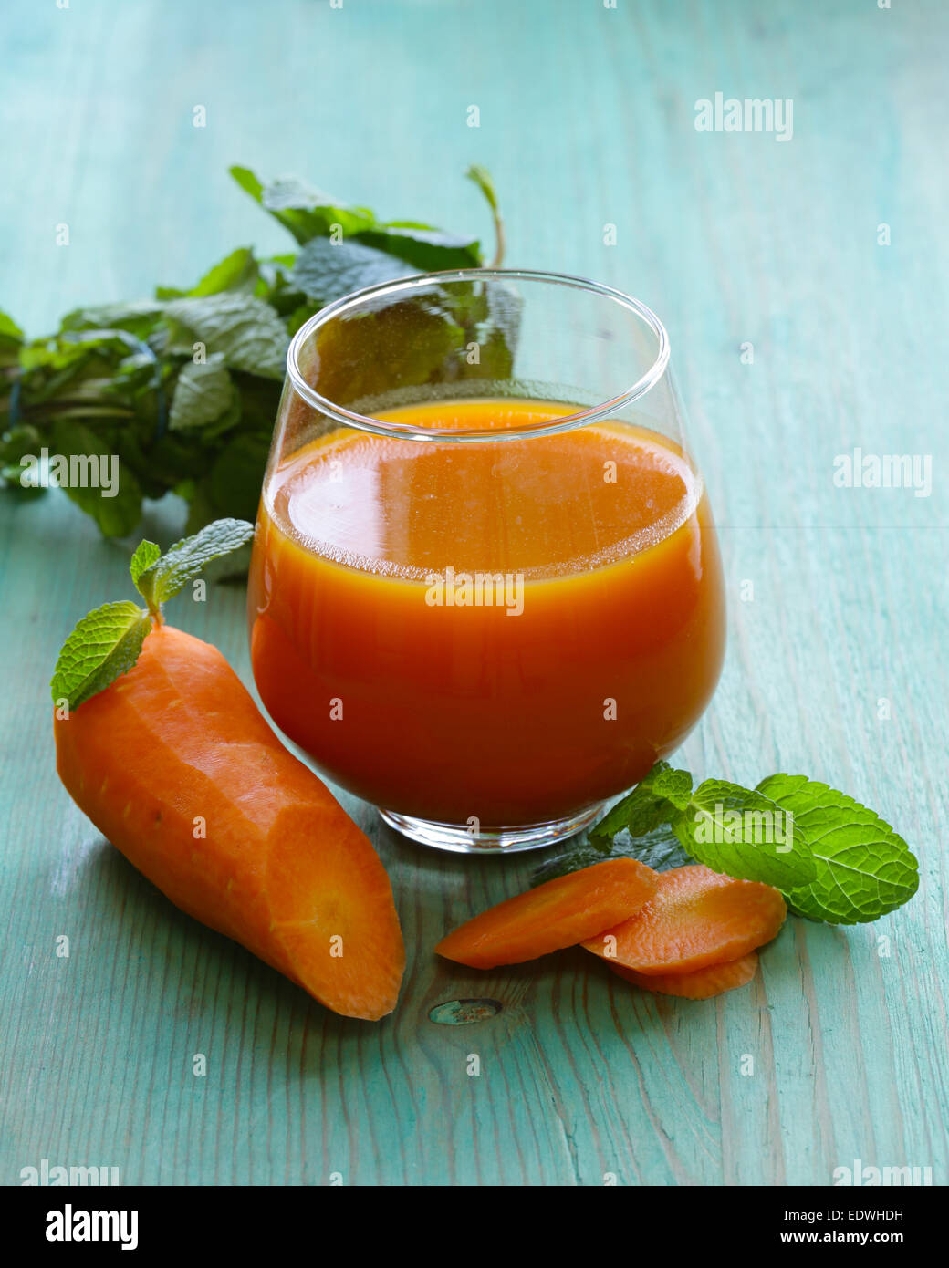 Fresco di succo di carota in vetro su un tavolo di legno Foto Stock
