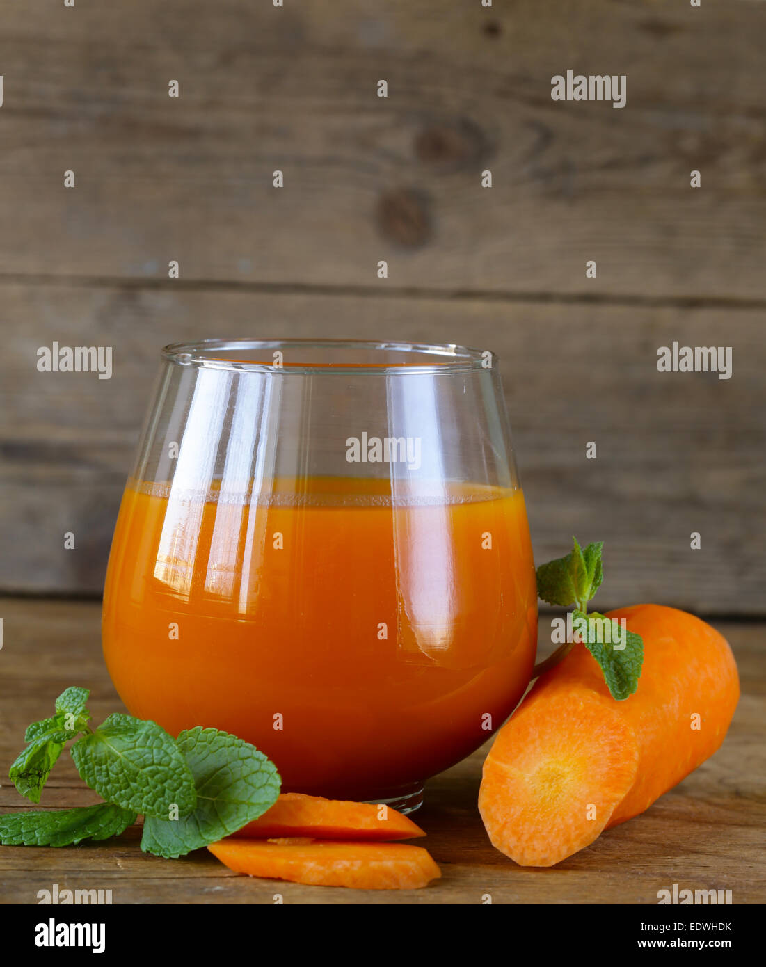 Fresco di succo di carota in vetro su un tavolo di legno Foto Stock
