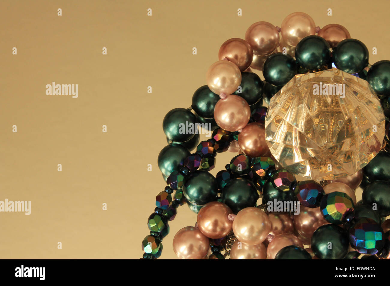 Gioielli colorati perle e collane che circonda un cristallo su uno specchio circondato da spazio negativo Foto Stock