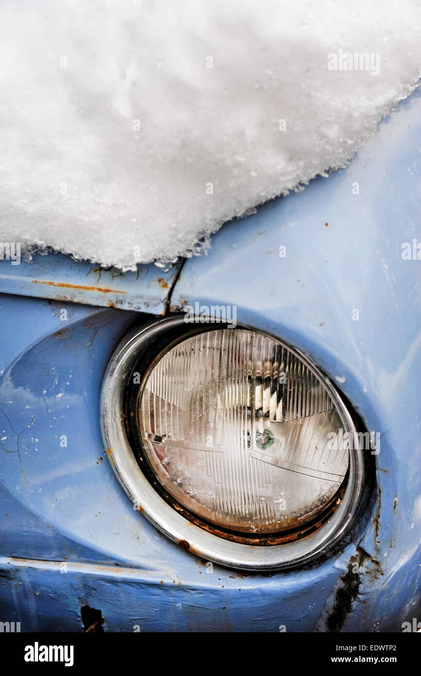 Dettaglio delle riprese con un faro di una vecchia auto in inverno Foto Stock