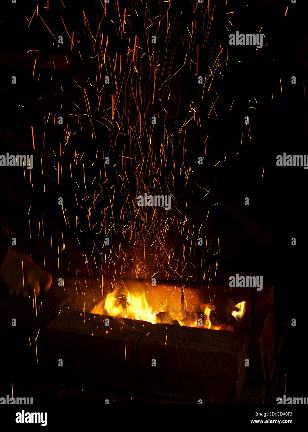 Il fuoco con scintille volanti closeup su sfondo scuro Foto Stock