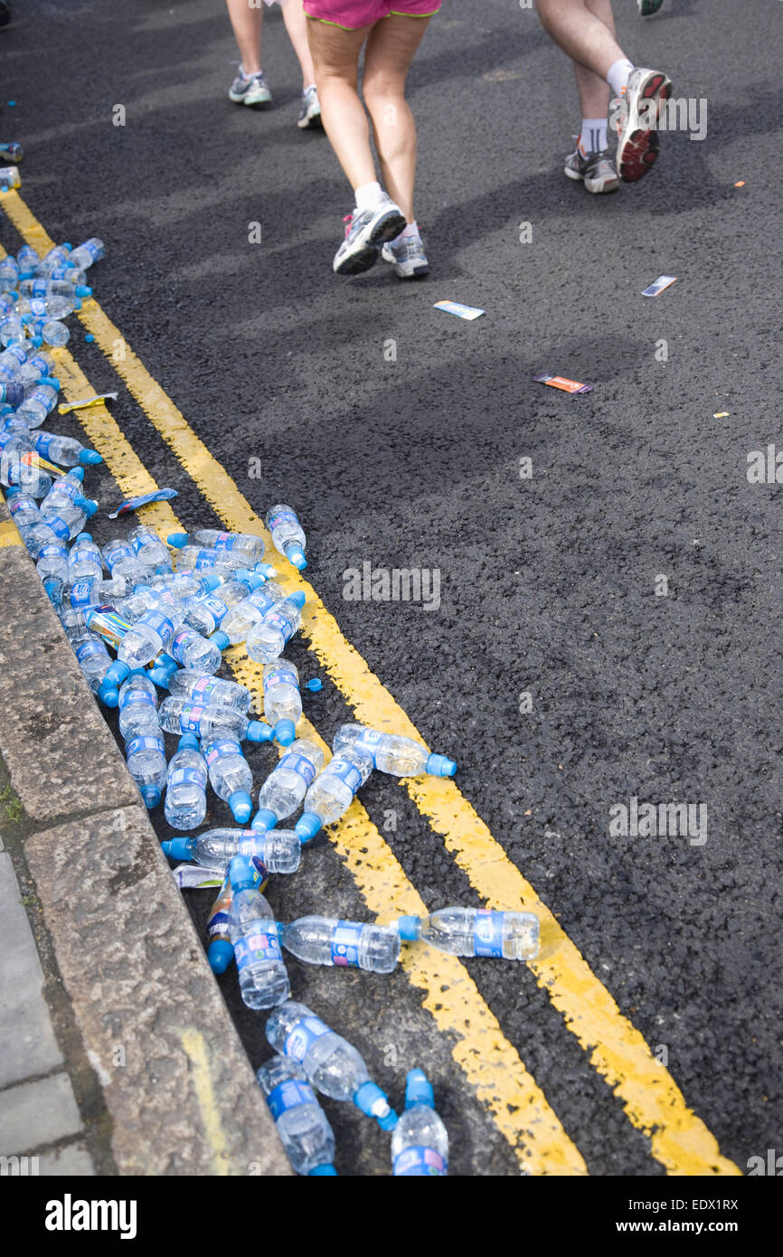 Bottiglie di acqua sul terreno e i partecipanti in esecuzione nella maratona di Londra Foto Stock