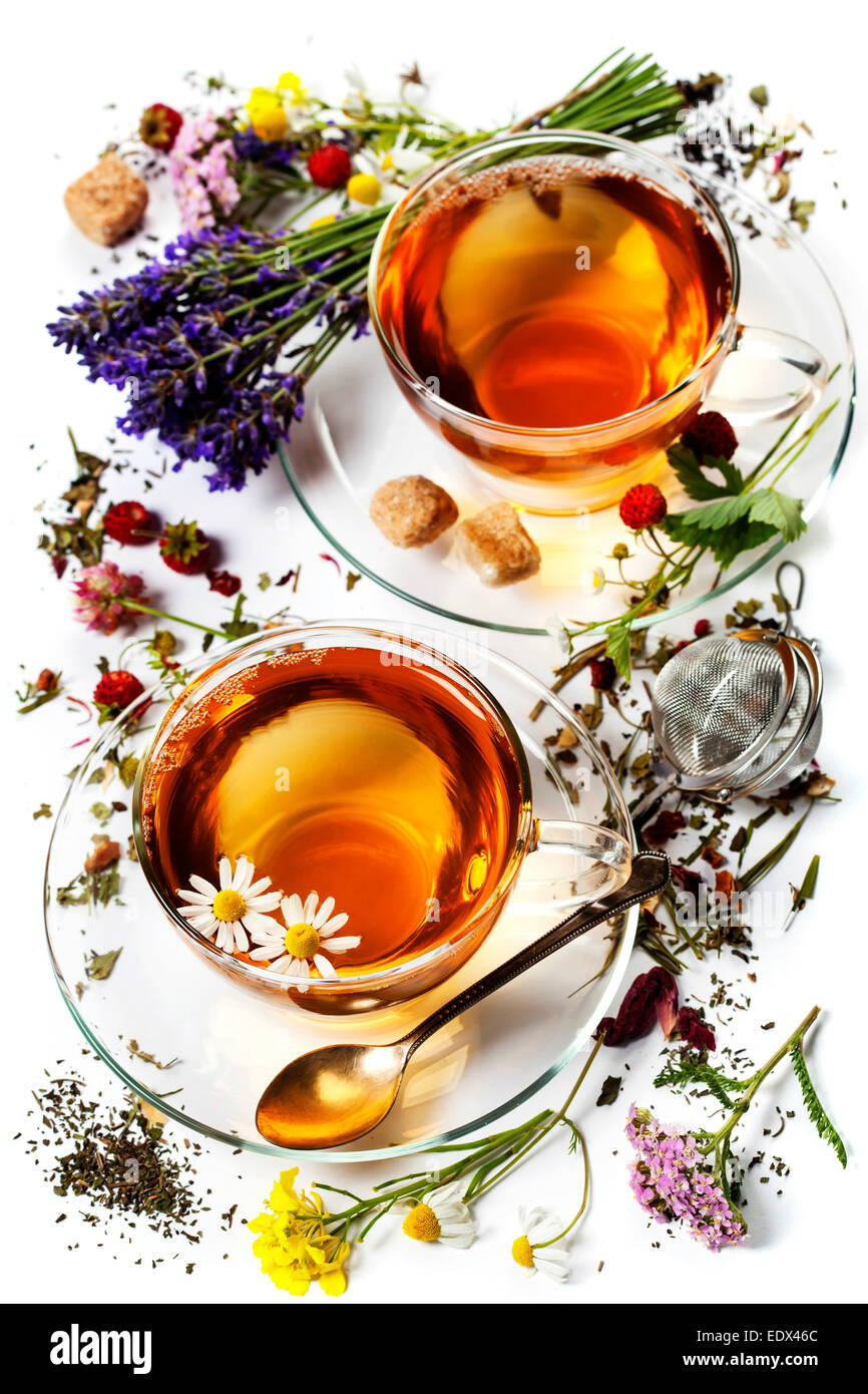 Il tè alle erbe con miele e frutti di bosco e fiori su sfondo di legno Foto Stock