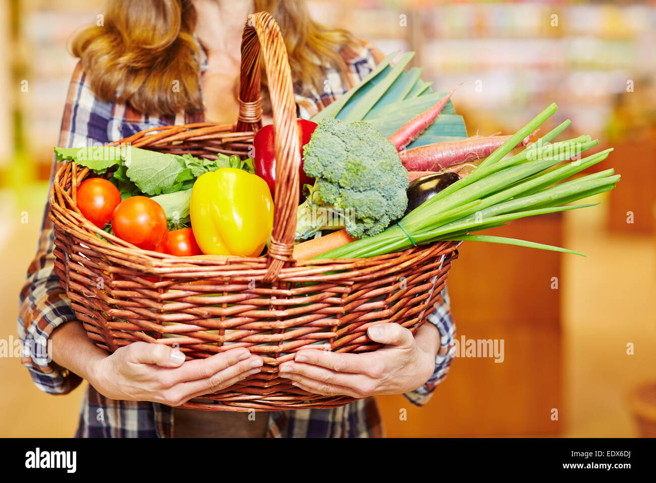 Mani che trasportano Shopping basket con verdure in un supermercato Foto Stock