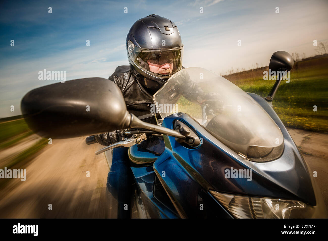 Biker in casco e giacca di pelle racing su strada Foto Stock Biker in casco e giacca di pelle racing su strada Foto Stock