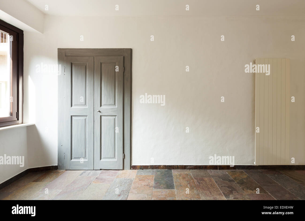 Porta chiusa in una casa rustica, pavimento in pietra Foto Stock