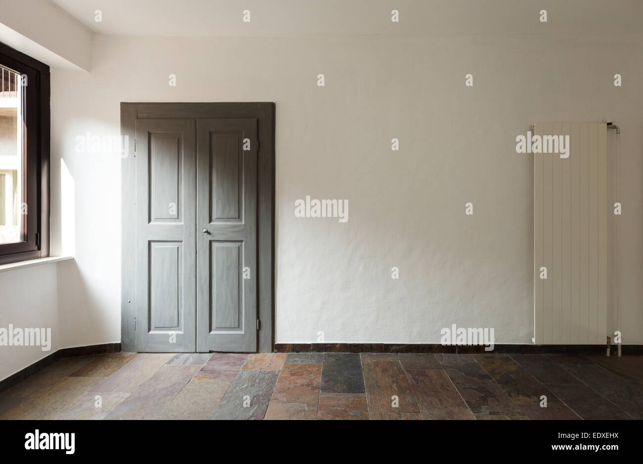 Porta chiusa in una casa rustica, pavimento in pietra Foto Stock