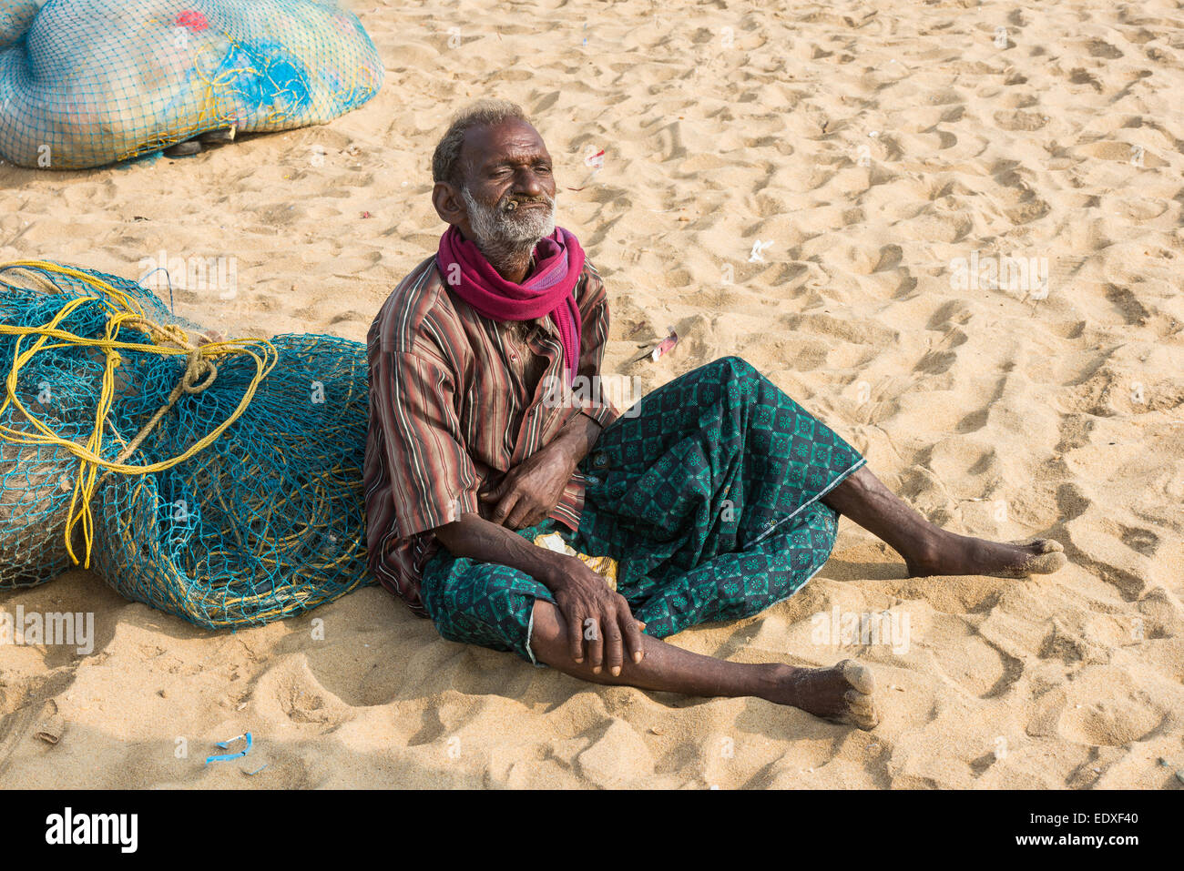 CHENNAI, India - 10 febbraio: un misterioso uomo si siede sulla sabbia vicino alla spiaggia di Marina il 10 febbraio 2013 a Chennai, India Foto Stock