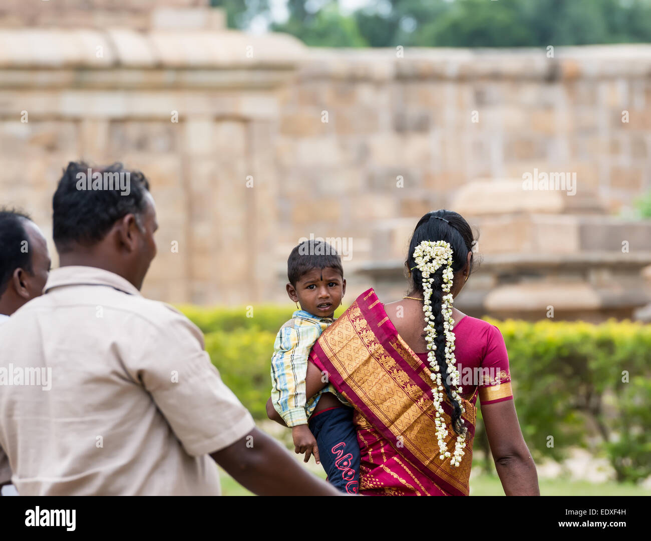 THANJAVOUR, India - 13 febbraio: Un indiano non identificato persona in abito nazionale di trasportare un bambino nelle mani. India, Tamil Na Foto Stock