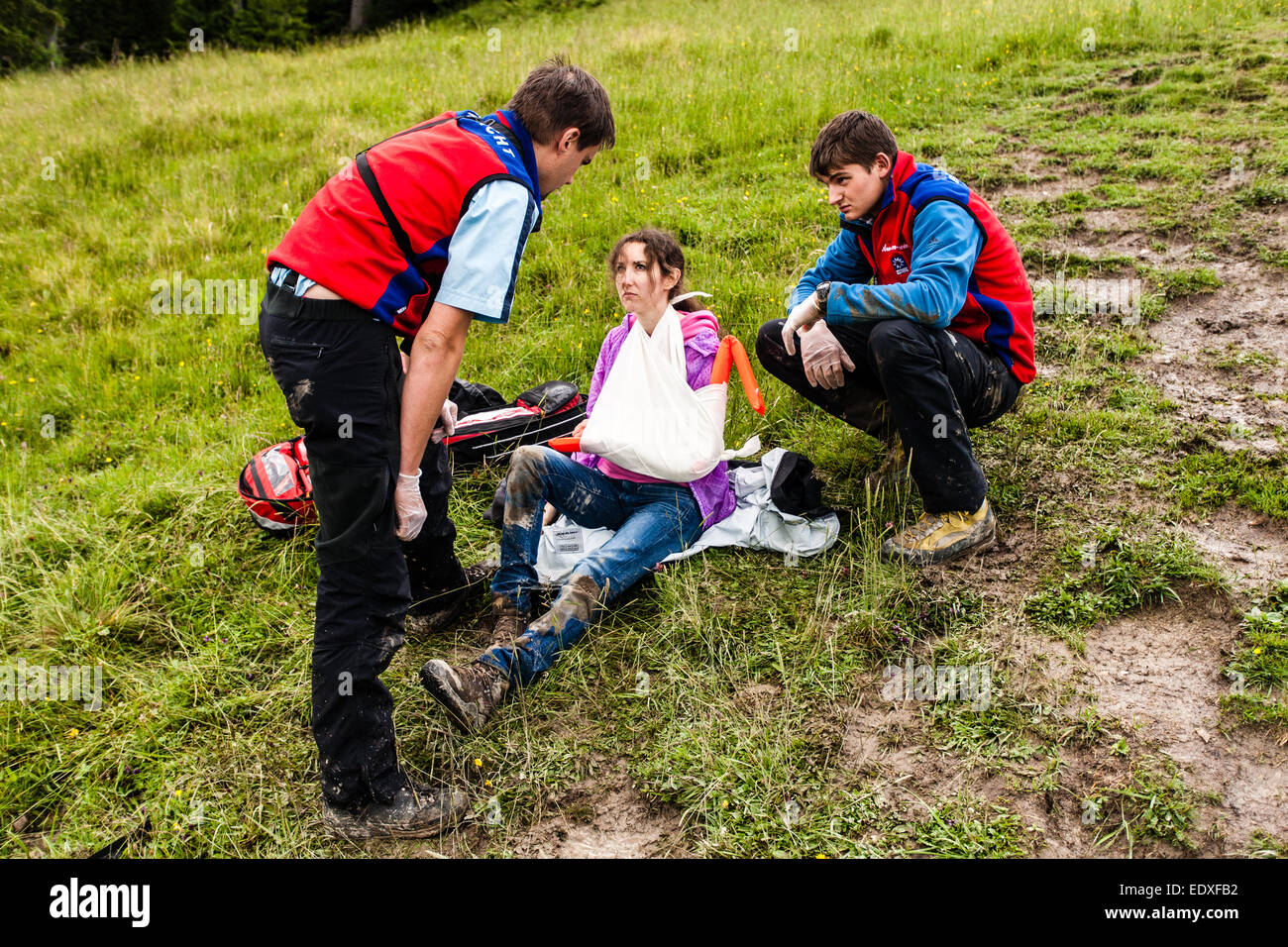 Donna di essere aiutato da mountain rescue team dopo la rottura il suo braccio dopo escursioni nelle Alpi Bavaresi, sulla montagna saturo di acqua Foto Stock