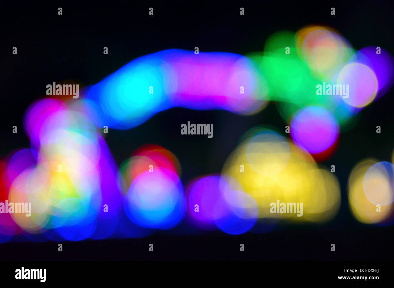 Lampeggio luci multicolori che sono state macchiate da zoom sulla lente della fotocamera durante l'esposizione prodotta questa insolita astratto e immagine di sfondo di arresto. Foto Stock