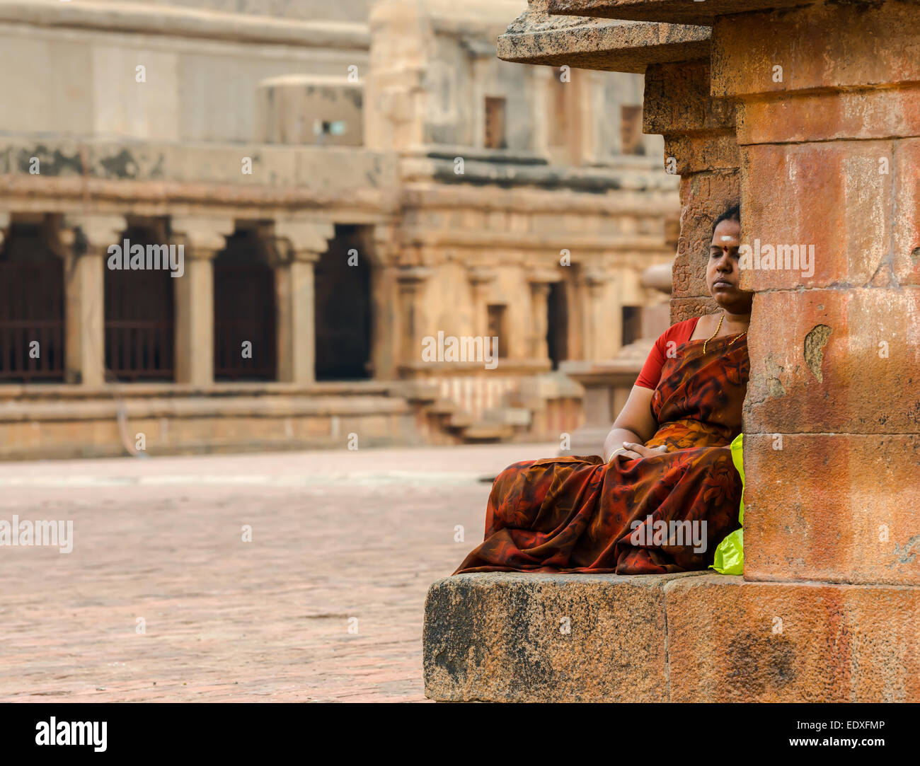 THANJAVOUR, India - 14 febbraio: non identificato una donna indiana in costumi nazionali si siede in Brihadeeswarar tempio indù. India, T Foto Stock