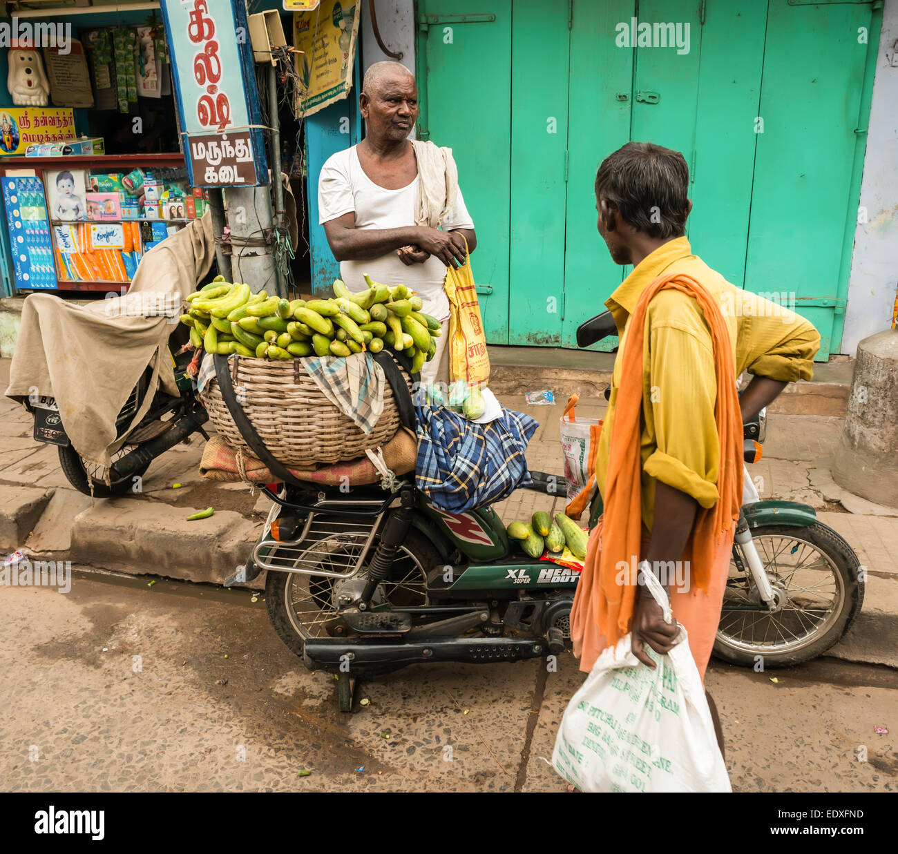 THANJAVOUR, India - 14 febbraio: una persona non identificata sono in piedi presso il motociclo con legumi tropicali. India, Tamil N Foto Stock