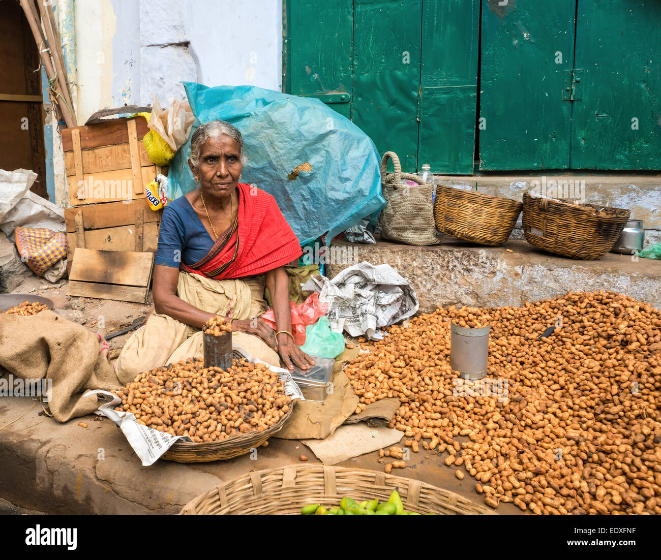 THANJAVOUR, India - 14 febbraio: una donna non identificato nel tradizionale abbigliamento indiano vende noccioline. La donna trattiene il denaro. India, Tam Foto Stock