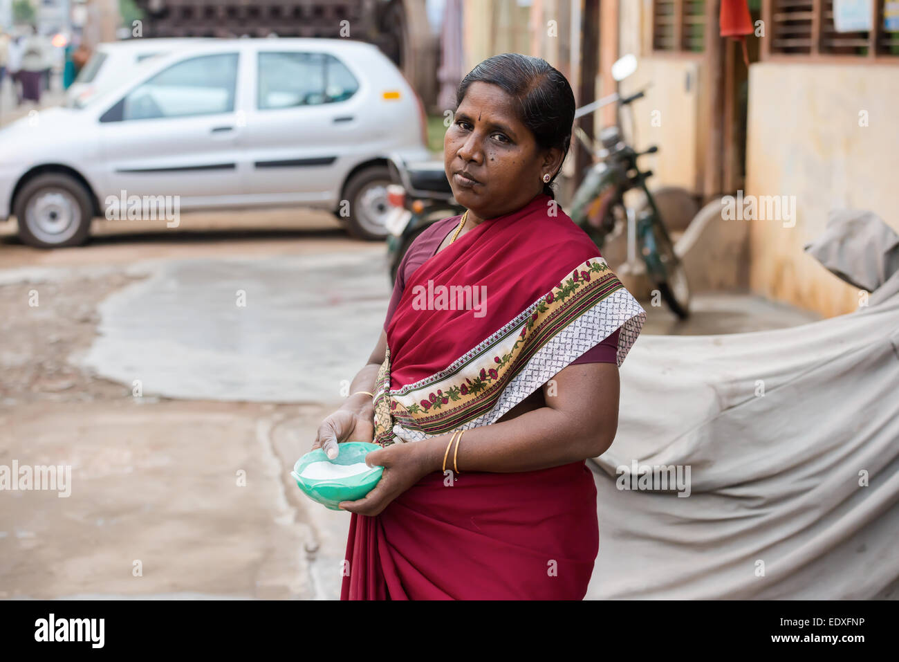 THANJAVOUR, India - 14 febbraio: una donna non identificato di capacità di contenimento con polvere di riso disegno su strada asfaltata. India, Tamil N Foto Stock