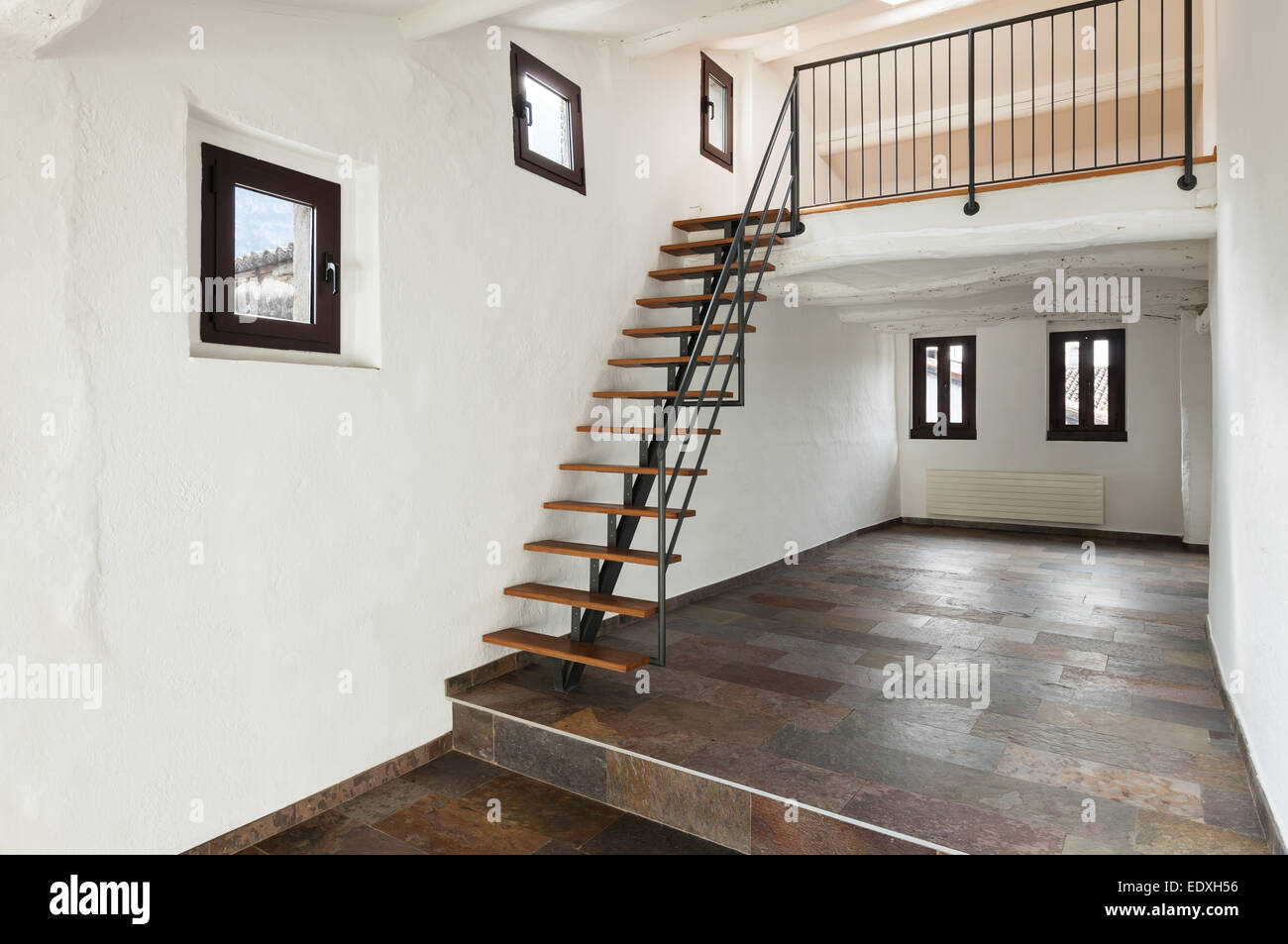 Interni rustici, camera grande con scala interna Foto Stock