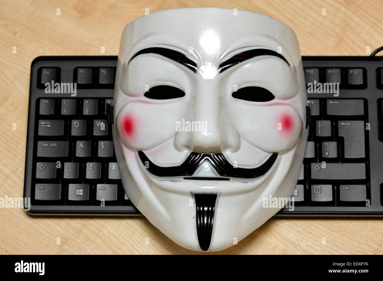 Anonimo maschera hacker giacente sulla tastiera di un computer Foto Stock