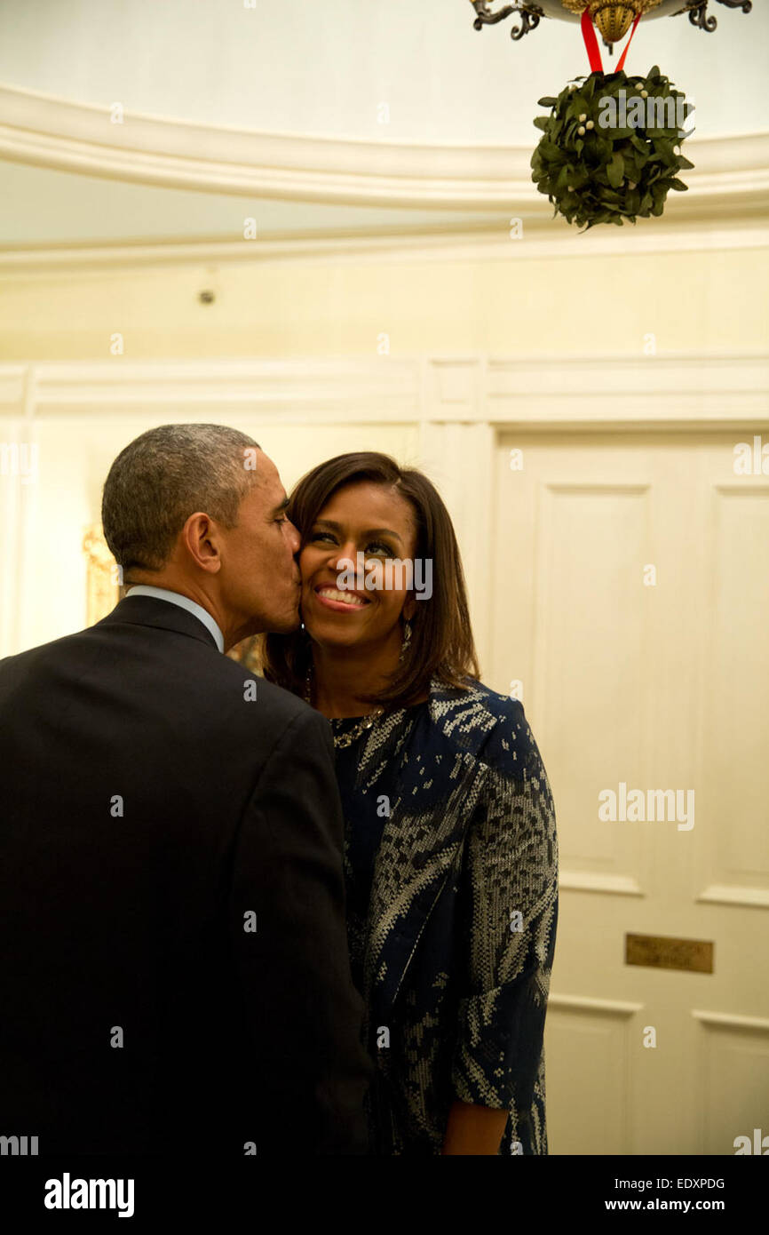 La First Lady macchiato il Presidente in piedi sotto il vischio e si trasferì in di agguantare un bacio da lui in seguito ad una cena per lottatori comandanti e leadership militare a Blair House di Washington, D.C. Foto Stock