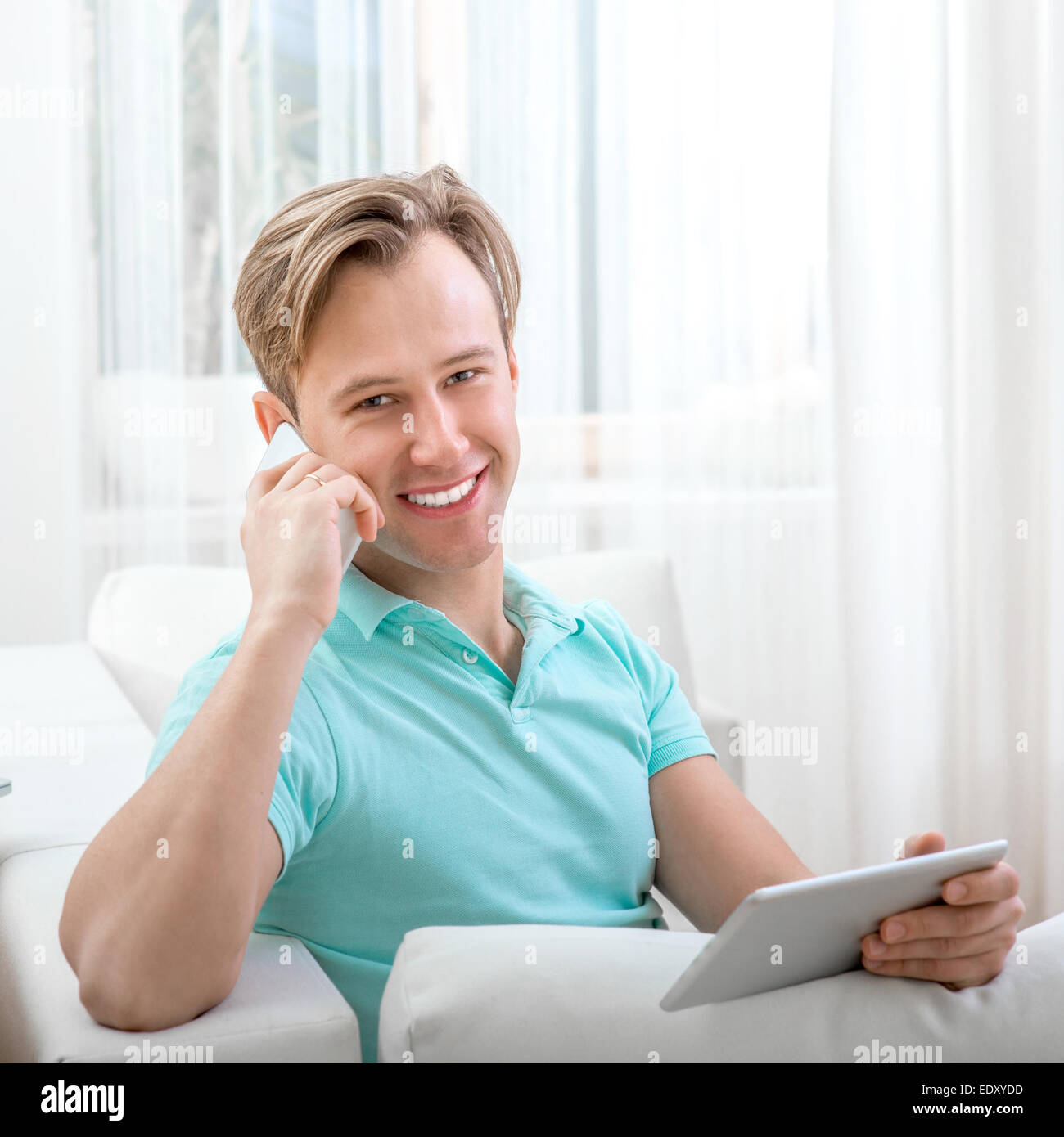 Uomo con gadget seduti a casa Foto Stock