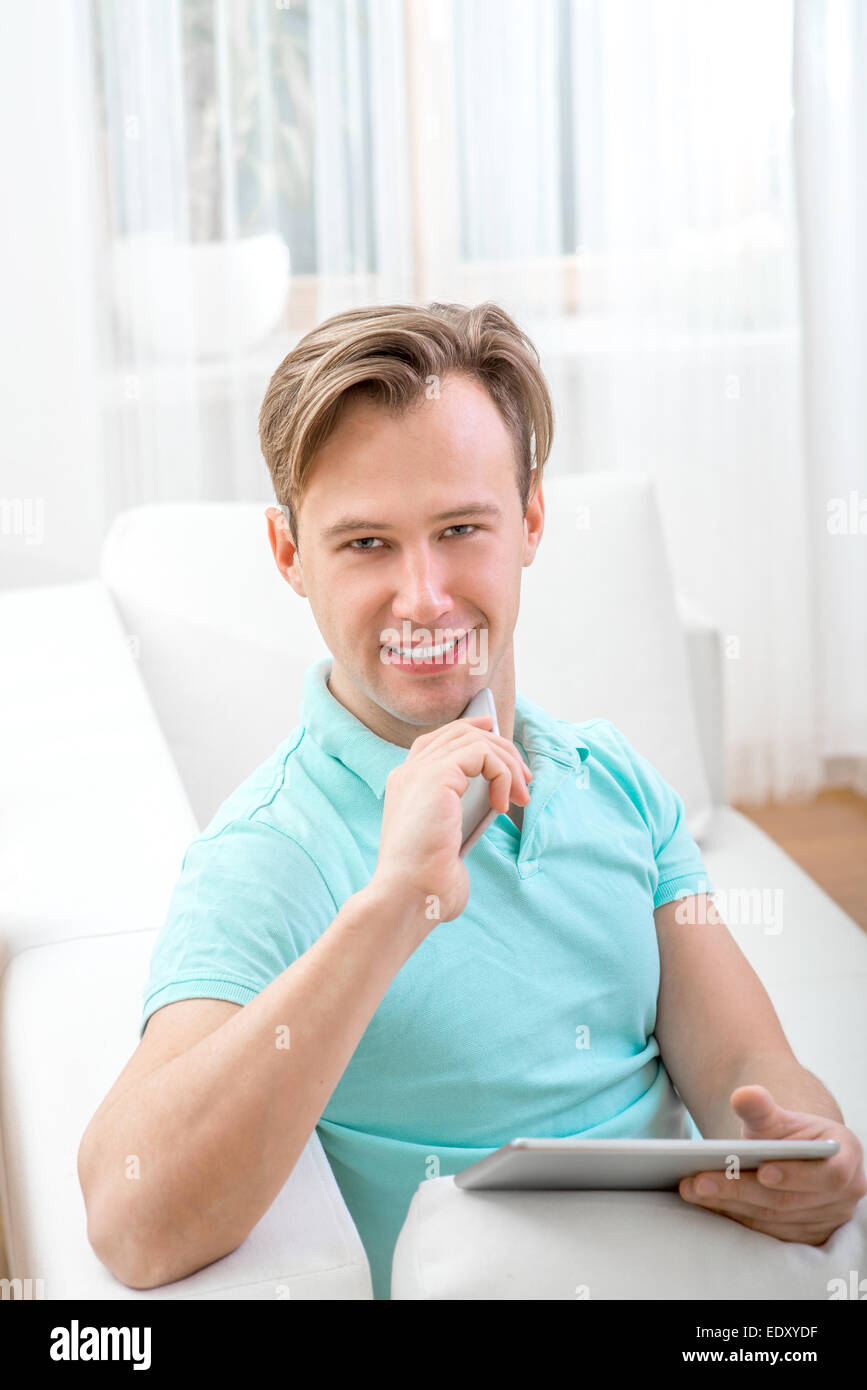 Uomo con gadget seduti a casa Foto Stock