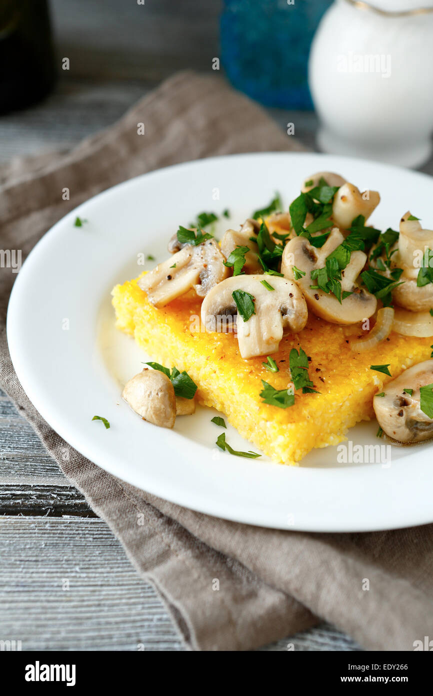 Gustosa la polenta con i funghi in una piastra bianca, cibo close up Foto Stock