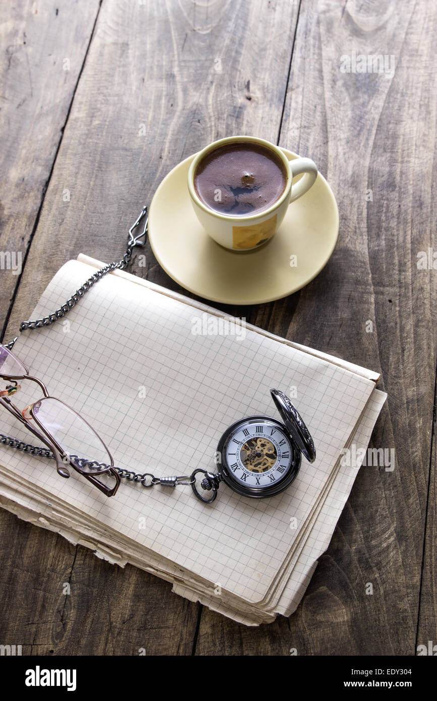 Vintage orologio da tasca con tazza di caffè sul vecchio libro closeup Foto Stock