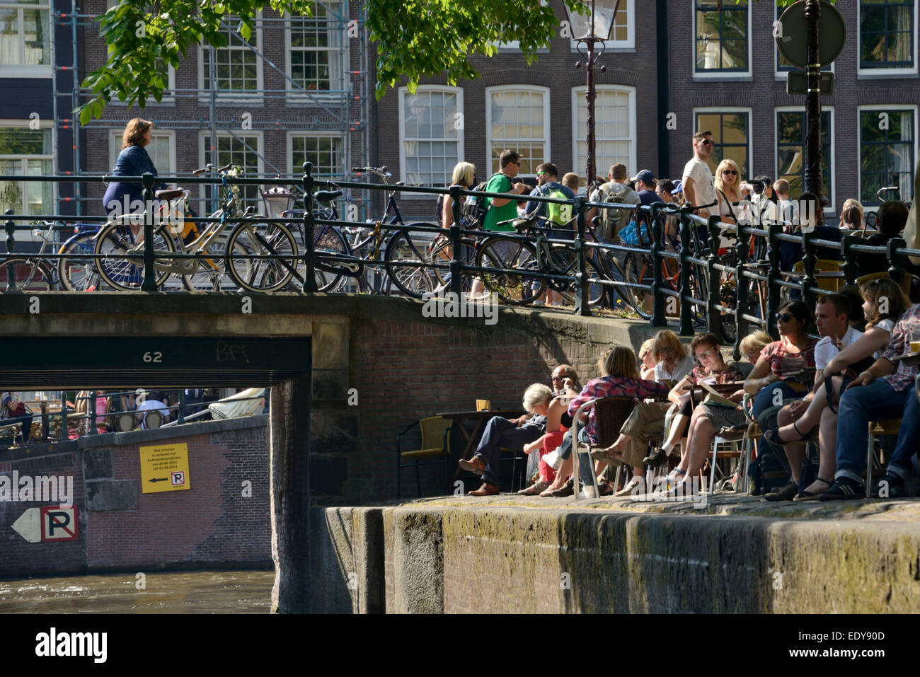 La gente seduta dalla banca Canale di Beagle, Amsterdam, Olanda Settentrionale, Paesi Bassi, Europa Foto Stock