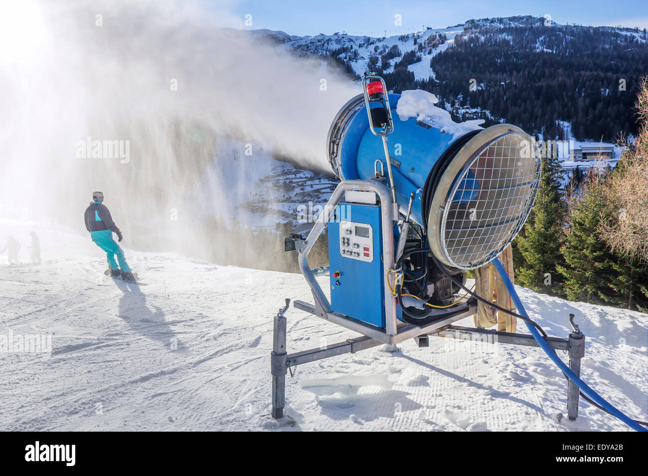 Neve cannoni, polvere di neve rendendo sulla pista da sci Nassfeld, Austria, con spruzzi retroilluminato Foto Stock