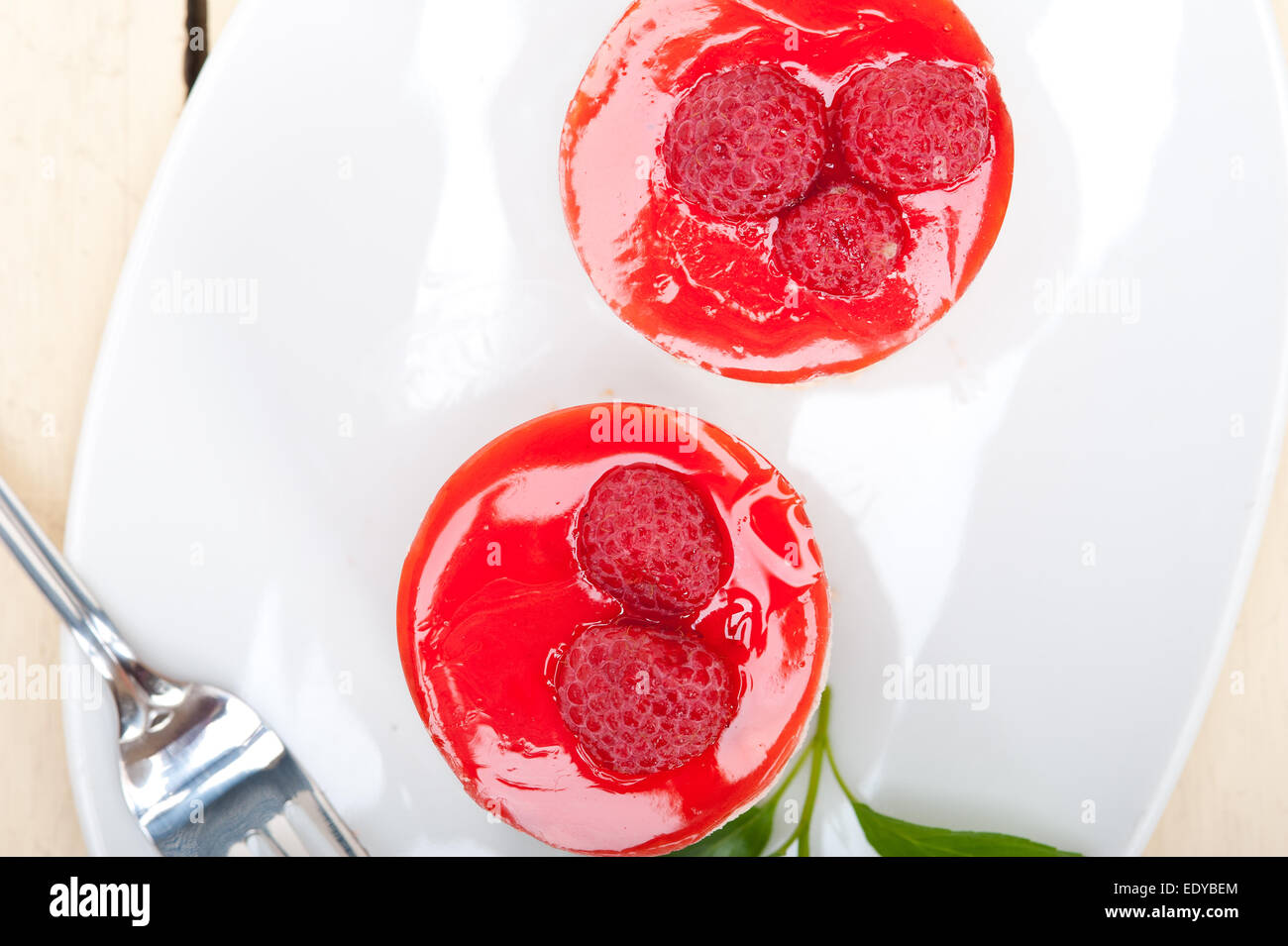 Fresche lamponi mousse torta dolce di forma rotonda con foglie di menta Foto Stock