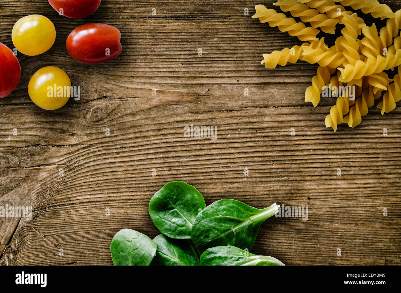 Pasta foglie di insalata e pomodori ciliegia su una tavola in legno rustico Foto Stock