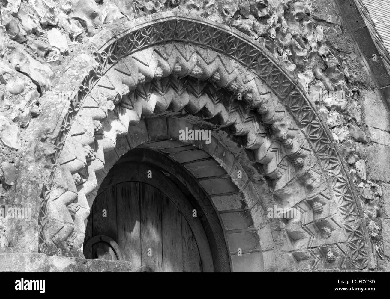 Arco intagliato con freccette, stelle e uva creduto alla data1140s sopra il portale sud della Chiesa Tortington, West Sussex Foto Stock