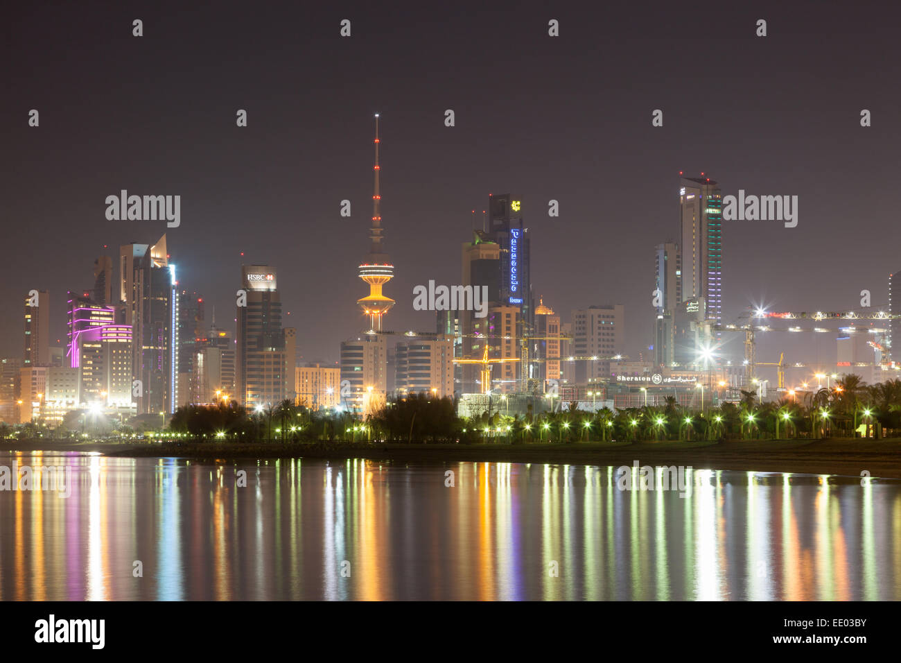 Skyline di Kuwait City illuminata di notte Foto Stock