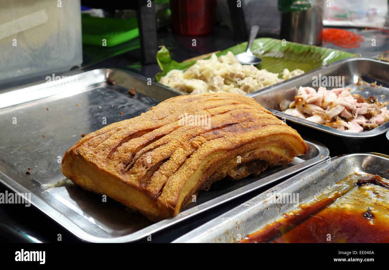 Arrosto di maiale croccante di pancetta, strada notte mercato intorno MBK shopping center, Bangkok, Thailandia, Sud-est asiatico. Foto Stock