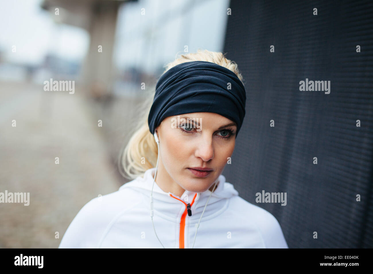 Donna Fitness cerca focalizzato mentre all'aperto per la sessione di formazione. Runner di sesso femminile che guarda lontano. Foto Stock