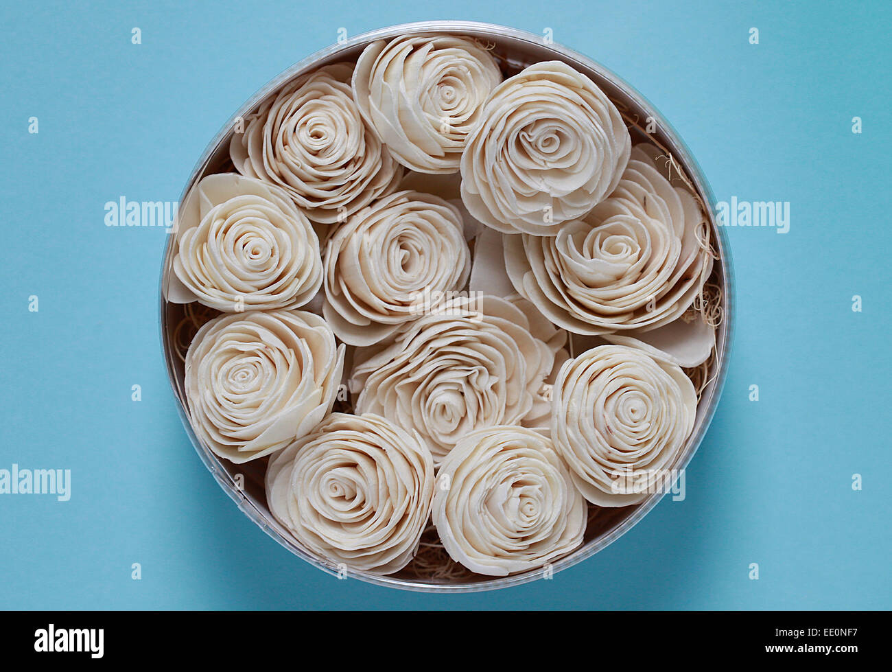 Close-up di fiori in tessuto nella scatola di acciaio con sfondo blu Foto Stock