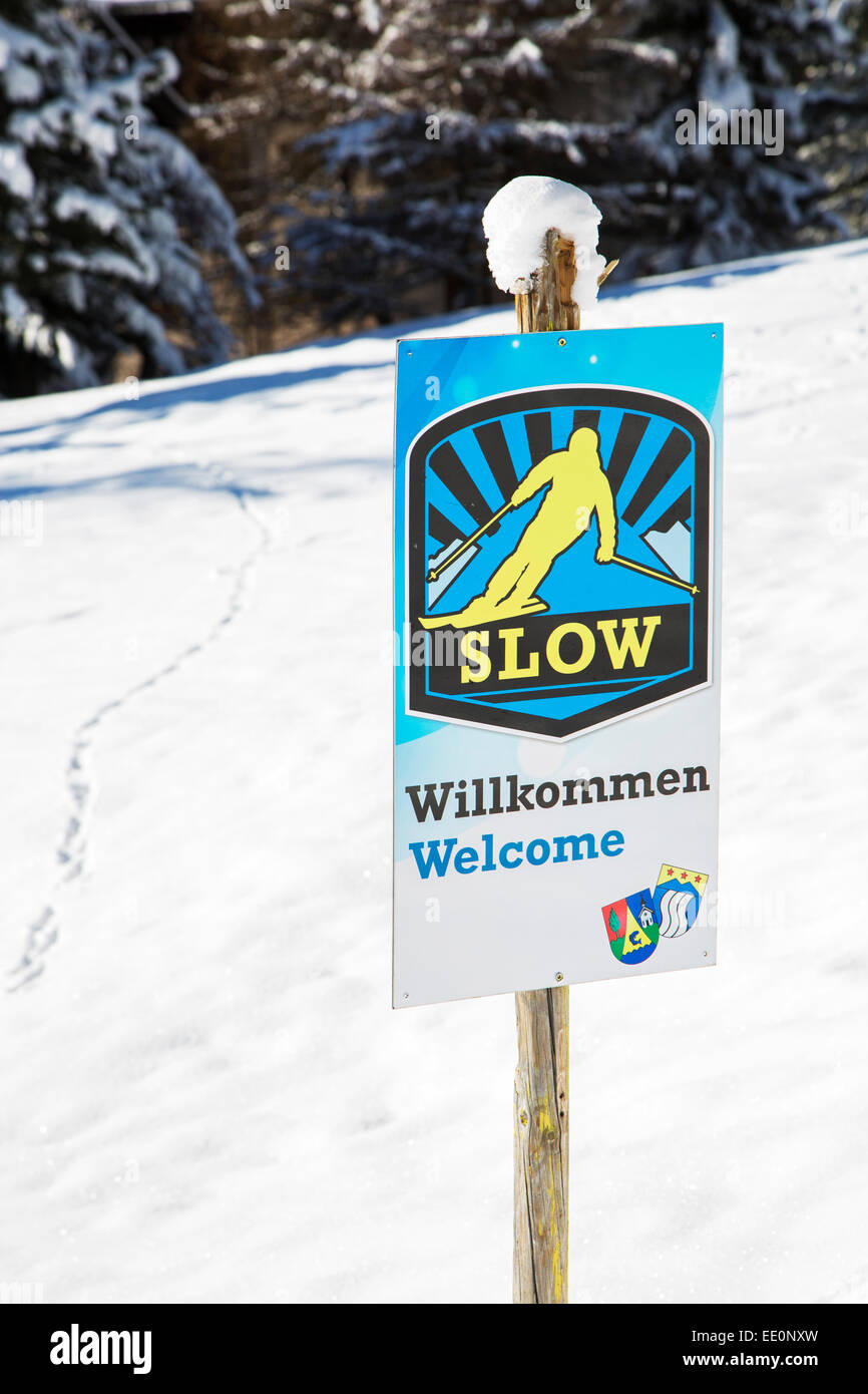 Segno di benvenuto sollecitando gli sciatori di sci lentamente in Alpine Ski station nelle alpi svizzere in inverno Foto Stock