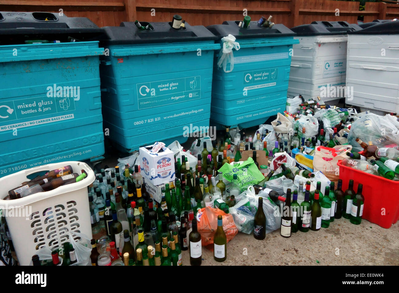 Bottiglie vuote a sinistra accanto al vaso traboccante banche Foto Stock