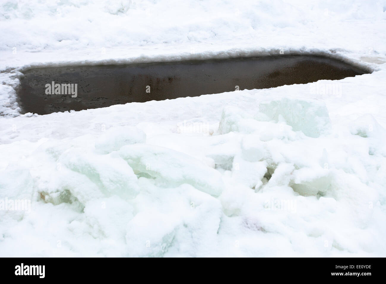 Glade con acqua congelata nel lago e blocchi di ghiaccio in inverno giorno Foto Stock