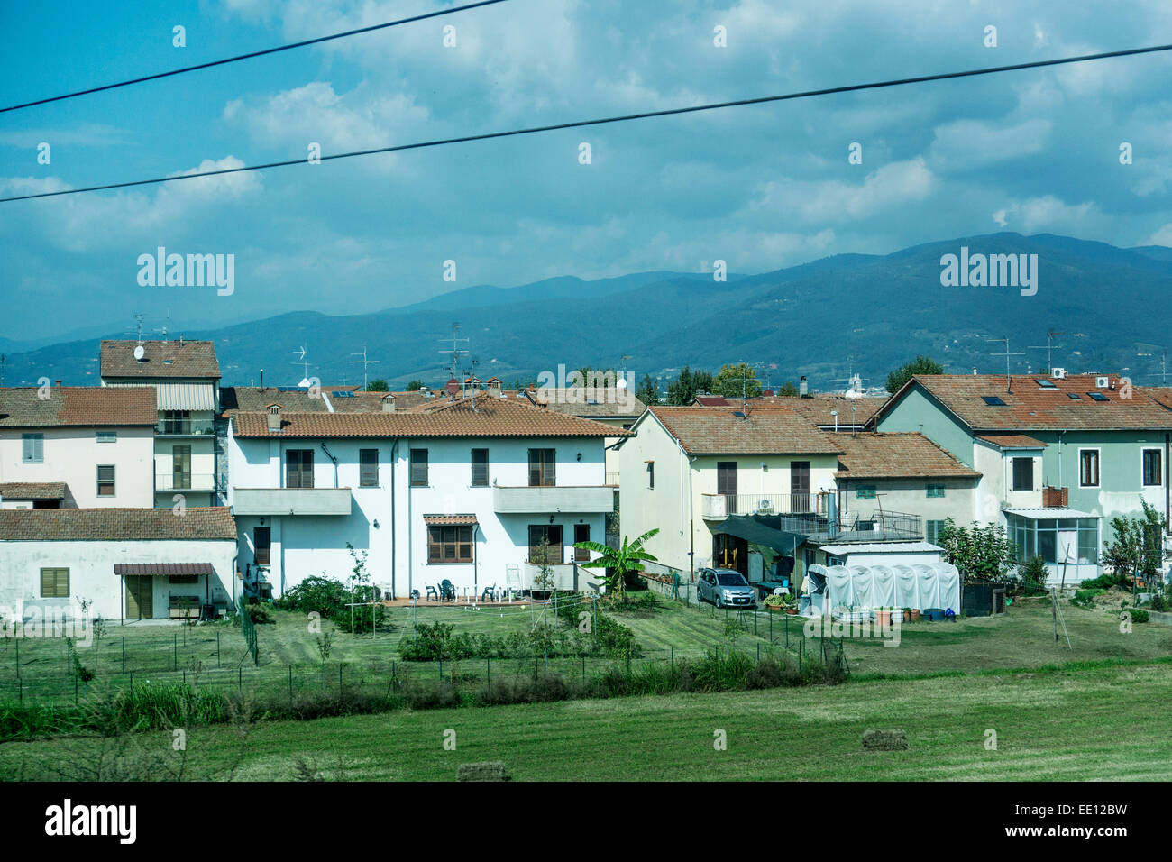 Piuttosto case con tetti in tegole rosse e il paese lifestyle invadono campi coltivati terreni agricoli in periferia di Firenze Italia Foto Stock