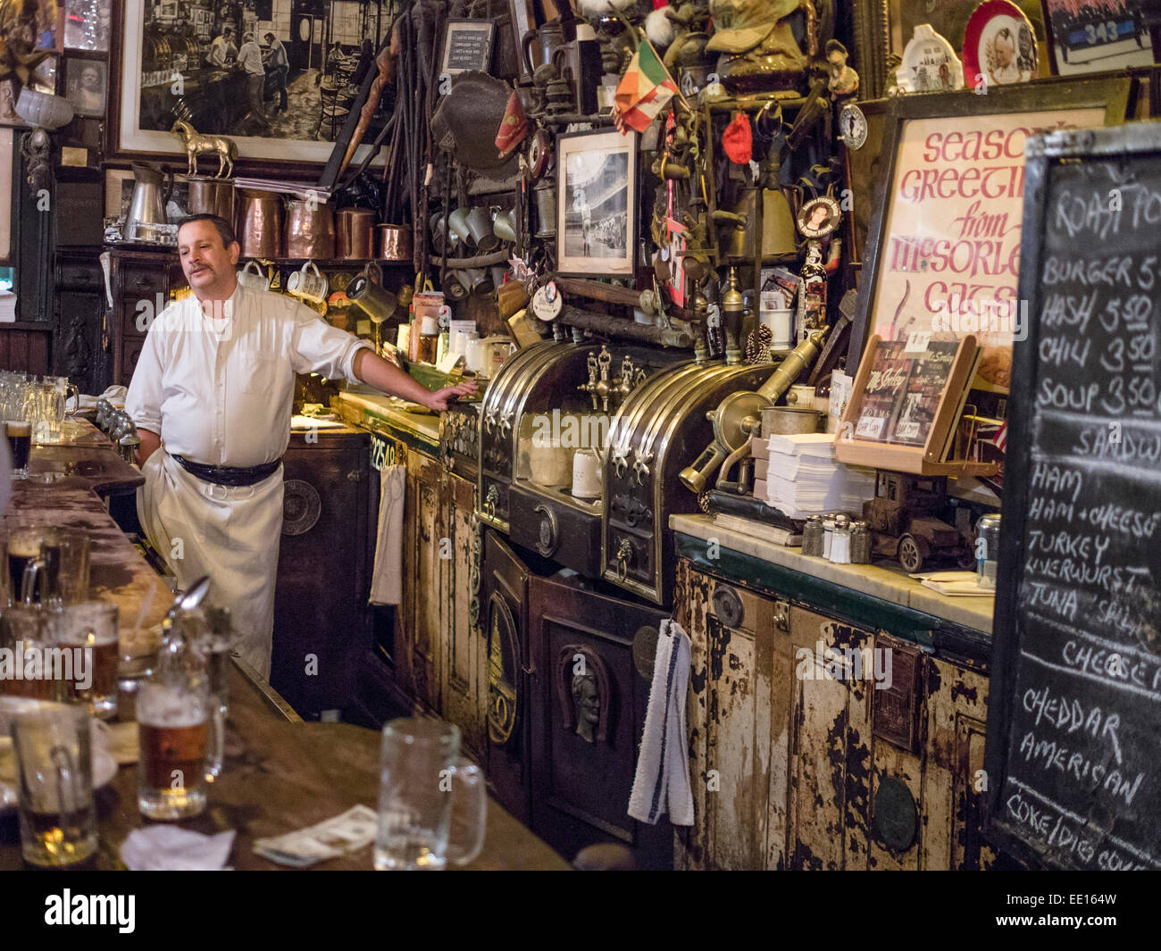 Dietro il bar a McSorley's Old Ale House. Il bar gara e ingombra di pareti di apparecchiature e memorabilia dietro il bar Foto Stock