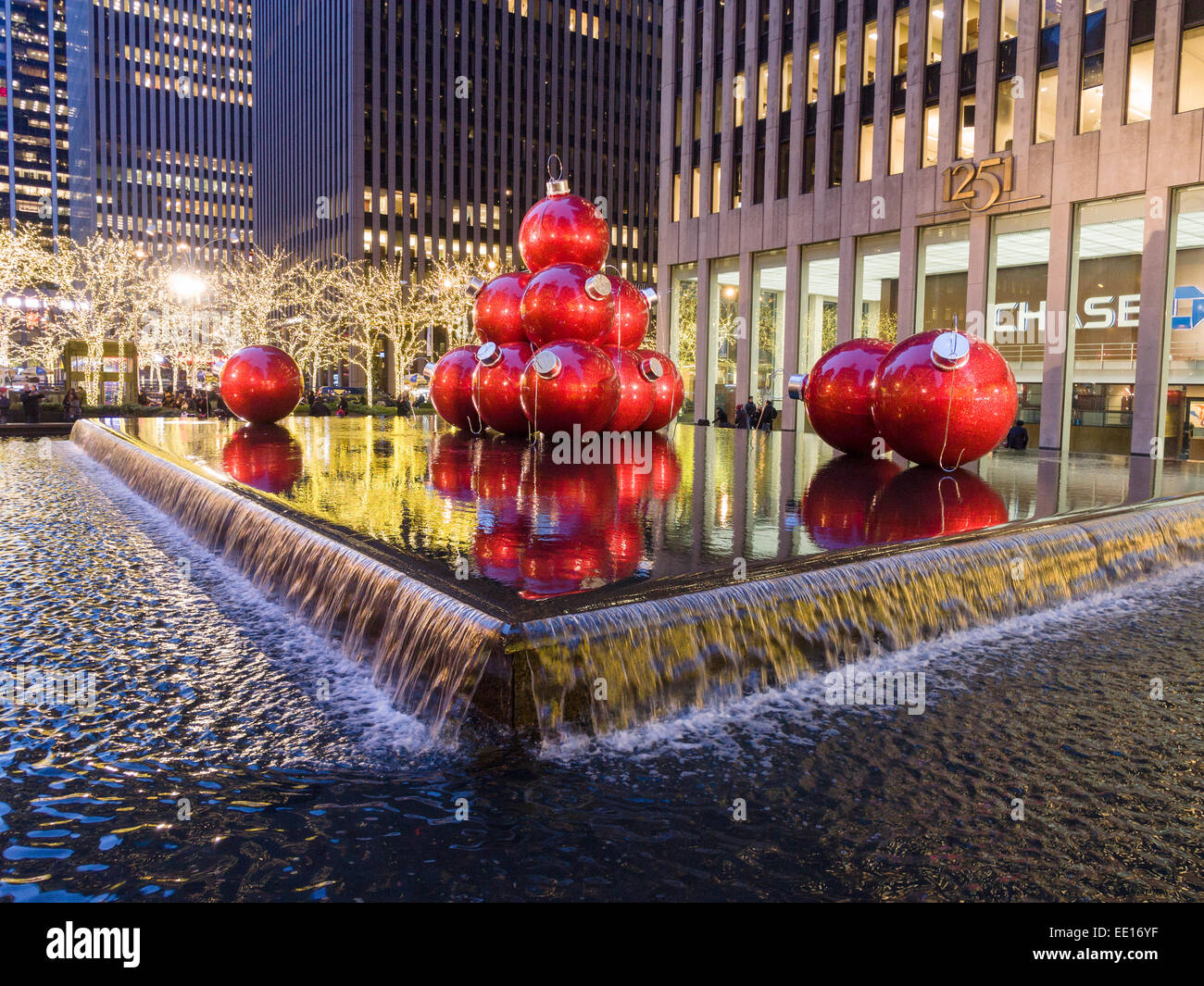 Gigante rosso Palle di Natale in una piscina a specchio. Vista serale di enormi palle di Natale messo annualmente in stagno riflettente e Foto Stock